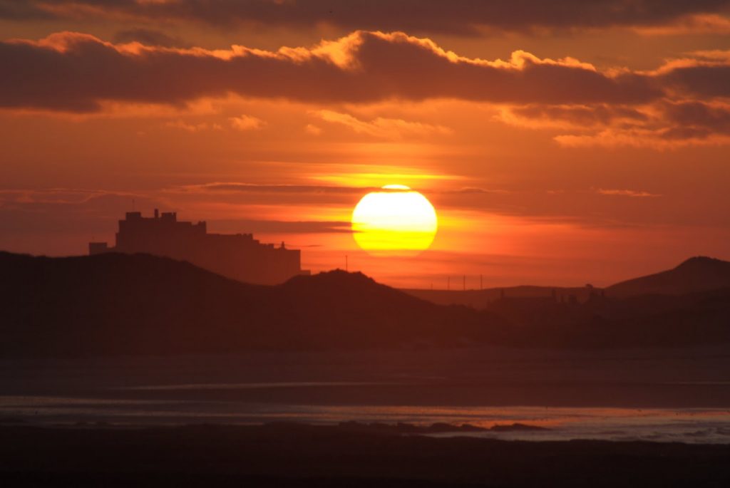 Sun setting over Bamburgh Castle